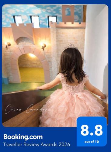 a little girl in a pink dress in front of a castle at Japan Family & Kids Castle Hotel Tokyo in Kisarazu