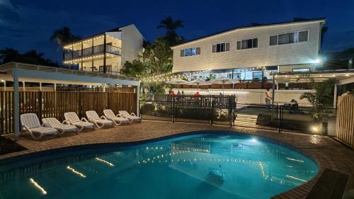 a swimming pool in front of a building at night at Somewhere To Stay Backpackers in Brisbane