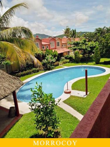 a swimming pool in front of a resort at Casa en Ixtapa 3 recamaras con alberca in Ixtapa