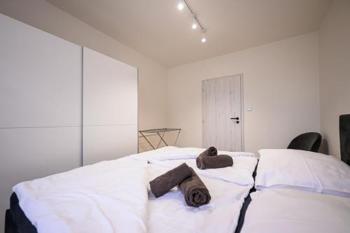 a bedroom with a large white bed with towels on it at Birdhouse Apartments in Prešov