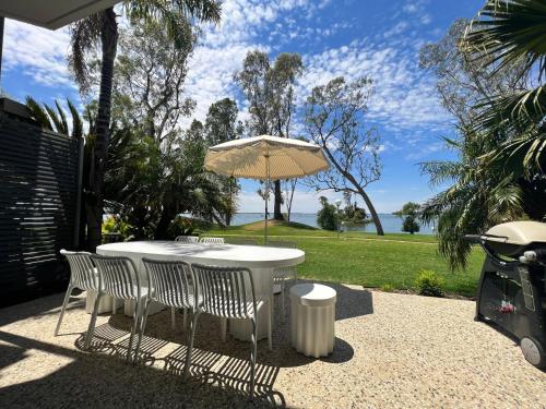 a white table with chairs and an umbrella at Villa Tarni Unit 7 in Mulwala
