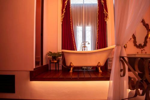 a bath tub in a bathroom with a window at La Casa Rosa Imperial in Mérida