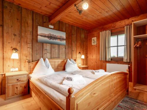 a bedroom with a bed in a wooden room at Weberhäusl am Penningberg in Hopfgarten im Brixental