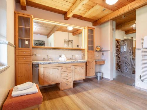 a bathroom with a sink and a large mirror at Weberhäusl am Penningberg in Hopfgarten im Brixental