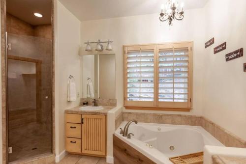 a bathroom with a tub and a shower and a sink at Hillside Hideaway - game rm - master spa - Luxury in Lake Arrowhead