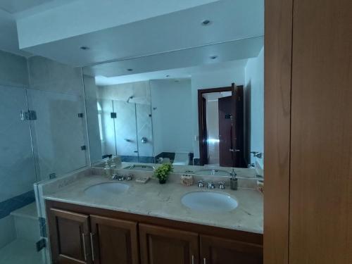 a bathroom with two sinks and a large mirror at BVG Villa 1 Norte in Ixtapa