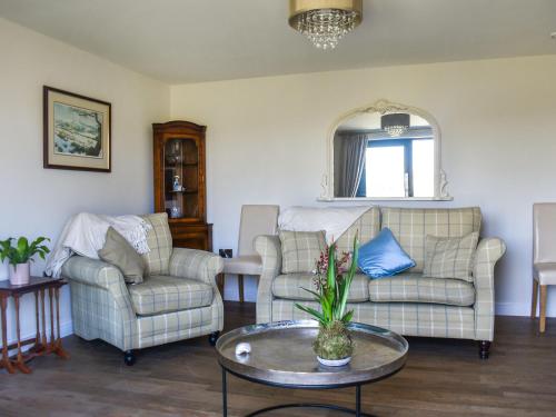 a living room with two chairs and a table at The Wolfs Den - Uk49083 in Winewall