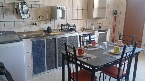 a kitchen with a table with chairs and a sink at Studio Figueira, Casa in Santarém