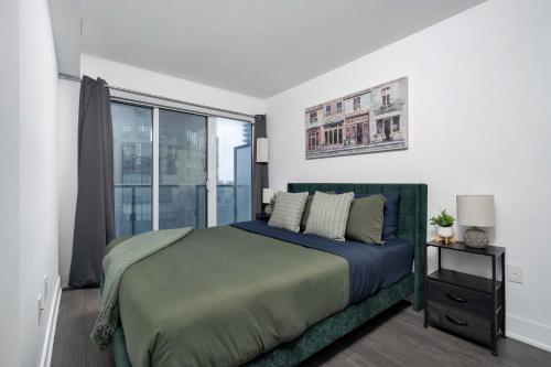 a bedroom with a bed and a large window at Pleasant 1BR Sofa Bed Close to UofT in Toronto