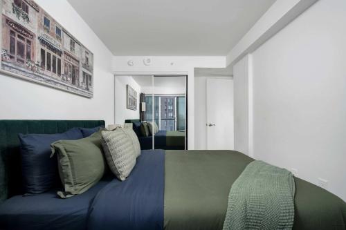 a bedroom with a blue bed and a couch at Pleasant 1BR Sofa Bed Close to UofT in Toronto
