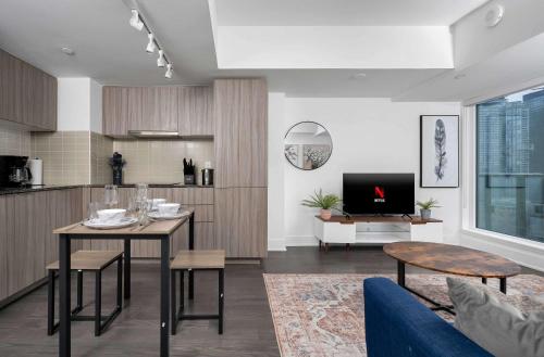 a living room with a table and a kitchen at Pleasant 1BR Sofa Bed Close to UofT in Toronto