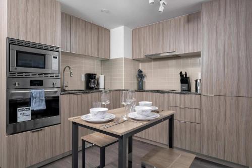 a kitchen with a table with plates and wine glasses at Pleasant 1BR Sofa Bed Close to UofT in Toronto