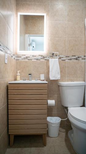 a bathroom with a sink and a toilet and a mirror at Stylish Studio Near Wynwood & Design District in Miami