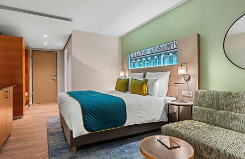 a hotel room with a bed and a couch at Leonardo Hotel Esslingen in Esslingen