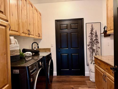 a kitchen with a black door and a dishwasher at Elegant Blackwood Grove by Casa Oso in Mariposa