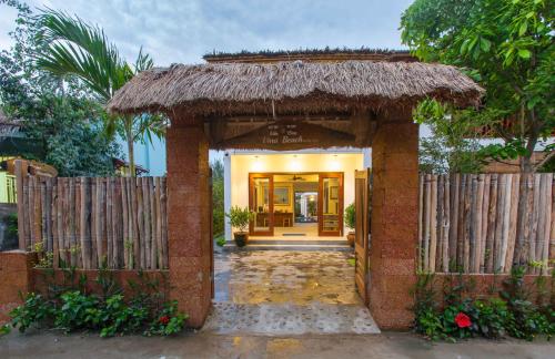 a entrance to a house with a straw roof at Vina Beach Pool Villas in Hoi An