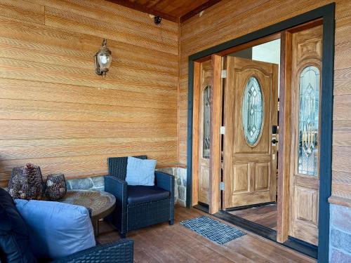 a living room with a couch and a wooden door at Elegant Blackwood Grove by Casa Oso in Mariposa