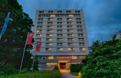 a tall building with a sign in front of it at Leonardo Hotel Karlsruhe in Karlsruhe