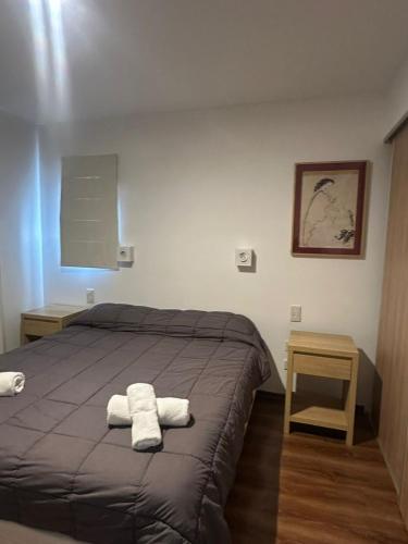 a bedroom with a bed with two towels on it at Lenga Hogar in El Calafate