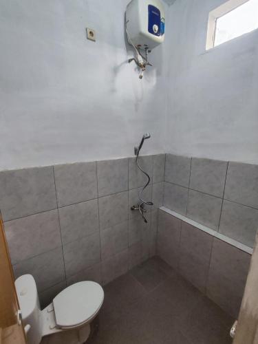 a bathroom with a toilet and a shower at Hotel Sarijadi Pangururan in Pangururan