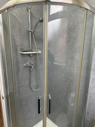 a shower stall with a glass door with a shower at Prentis Road in London