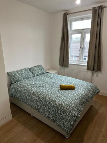 a bedroom with a bed with a yellow object on it at Prentis Road in London