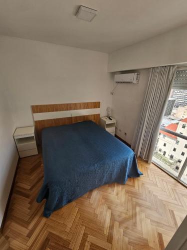 a bedroom with a bed with a blue blanket at Aire Porteño in La Porteña