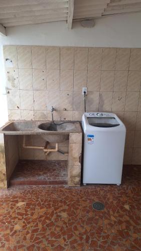 a bathroom with a sink and a washing machine at Casa para 6 pessoas completa in Ribeirão Preto