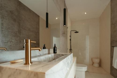 a bathroom with a large marble sink and a toilet at The Iggy Villa 2BR in Cemagi
