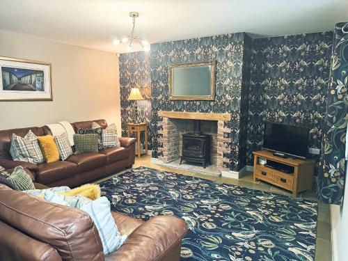a living room with a couch and a fireplace at John Wesley Cottage in Tantobie