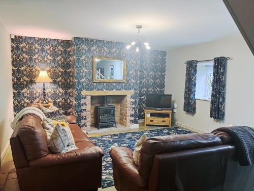 a living room with a couch and a fireplace at John Wesley Cottage in Tantobie