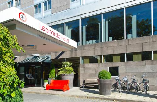 a building with a red chair in front of it at Leonardo Hotel Munich Arabellapark in Munich