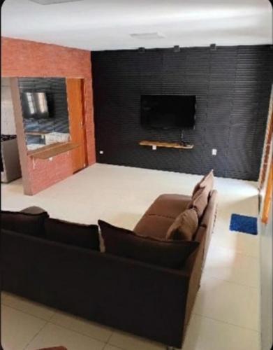 a living room with a couch and a flat screen tv at Casa completa in Marechal Deodoro