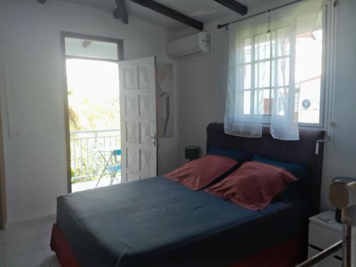 a bedroom with a bed and a window at LE VERDOYANT in Sainte-Anne