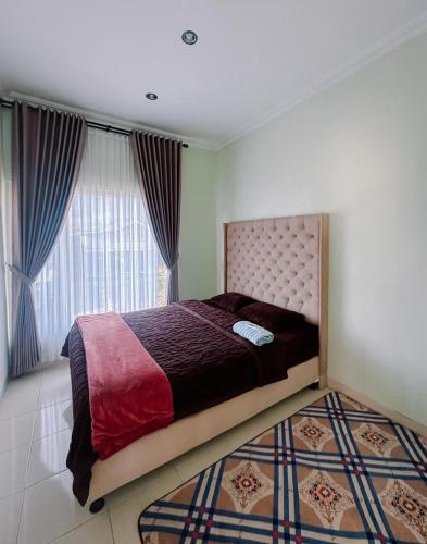a bedroom with a large bed and a window at Homestay Gavilla Dieng in Diyeng