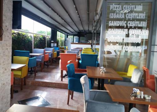 a restaurant with colorful chairs and tables and a window at Berrak Su Hotel in Antalya