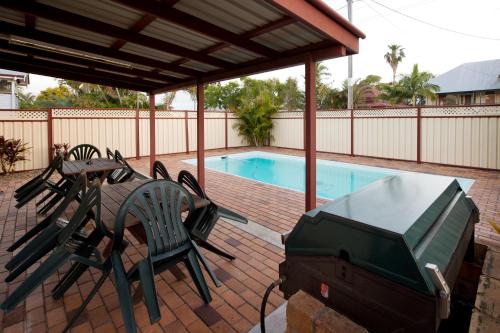a patio area with chairs and a pool at Mineral Sands Motel in Maryborough