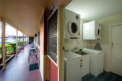 a kitchen with a sink and a refrigerator at Mineral Sands Motel in Maryborough