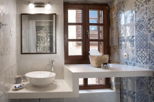 baño con lavabo, espejo y ventana en C&M Residence Chania Old Town, en La Canea