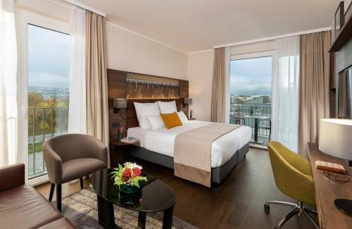 a hotel room with a bed and a large window at Leonardo Hotel Bad Kreuznach in Bad Kreuznach