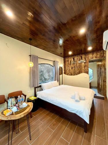 a bedroom with a large bed and a table at Pristine nature - Romantic - Green trees and lakes in Vũ Lâm