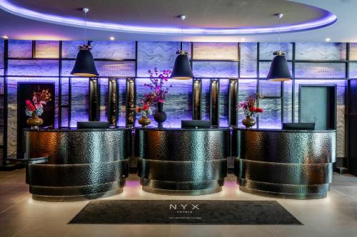 a lobby with two tables with flowers on them at NYX Hotel Hamburg by Leonardo Hotels in Hamburg