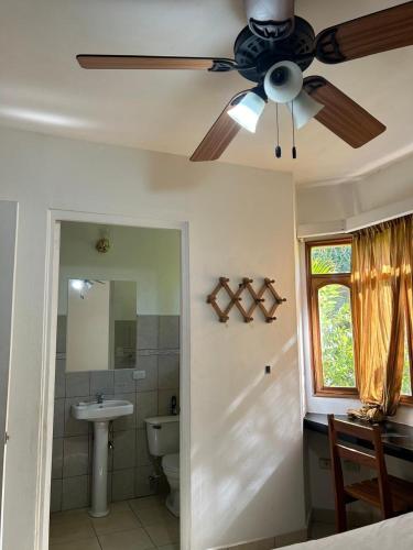 a bathroom with a ceiling fan and a sink at Casa amueblada in Jinotepe