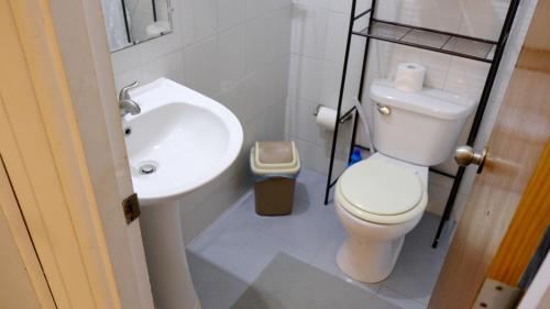 a bathroom with a white toilet and a sink at Comoda casa en segunda planta in Coamo