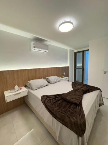 a bedroom with a large bed with a blanket on it at Edifício Catamara in Vila Velha