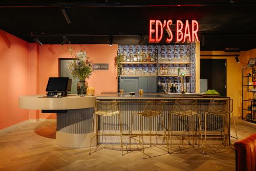 a bar in a restaurant with a bar stools at Leonardo Hotel Amsterdam Leidse Square in Amsterdam