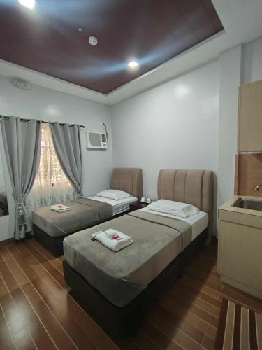 a hotel room with two beds and a kitchen at Mizpah Apartelle in Tagbilaran City