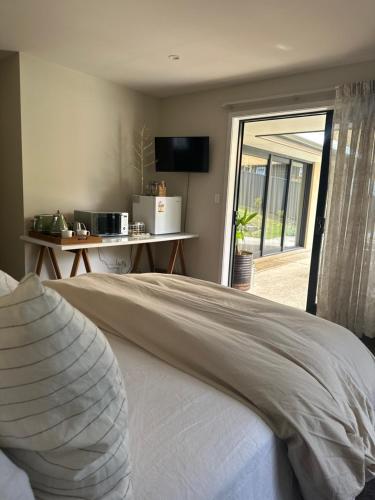 a bedroom with a bed and a sliding glass door at The Garden Room in Clyde