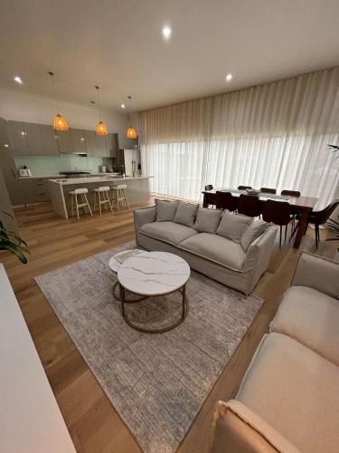 a living room with a couch and a table at Vida Hamilton - 3 bed, 2 bath kids playground! in Hamilton