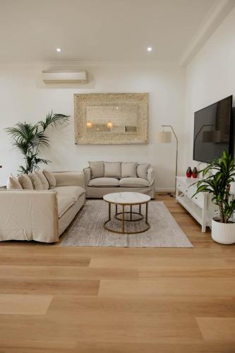 a living room with a couch and a table at Vida Hamilton - 3 bed, 2 bath kids playground! in Hamilton
